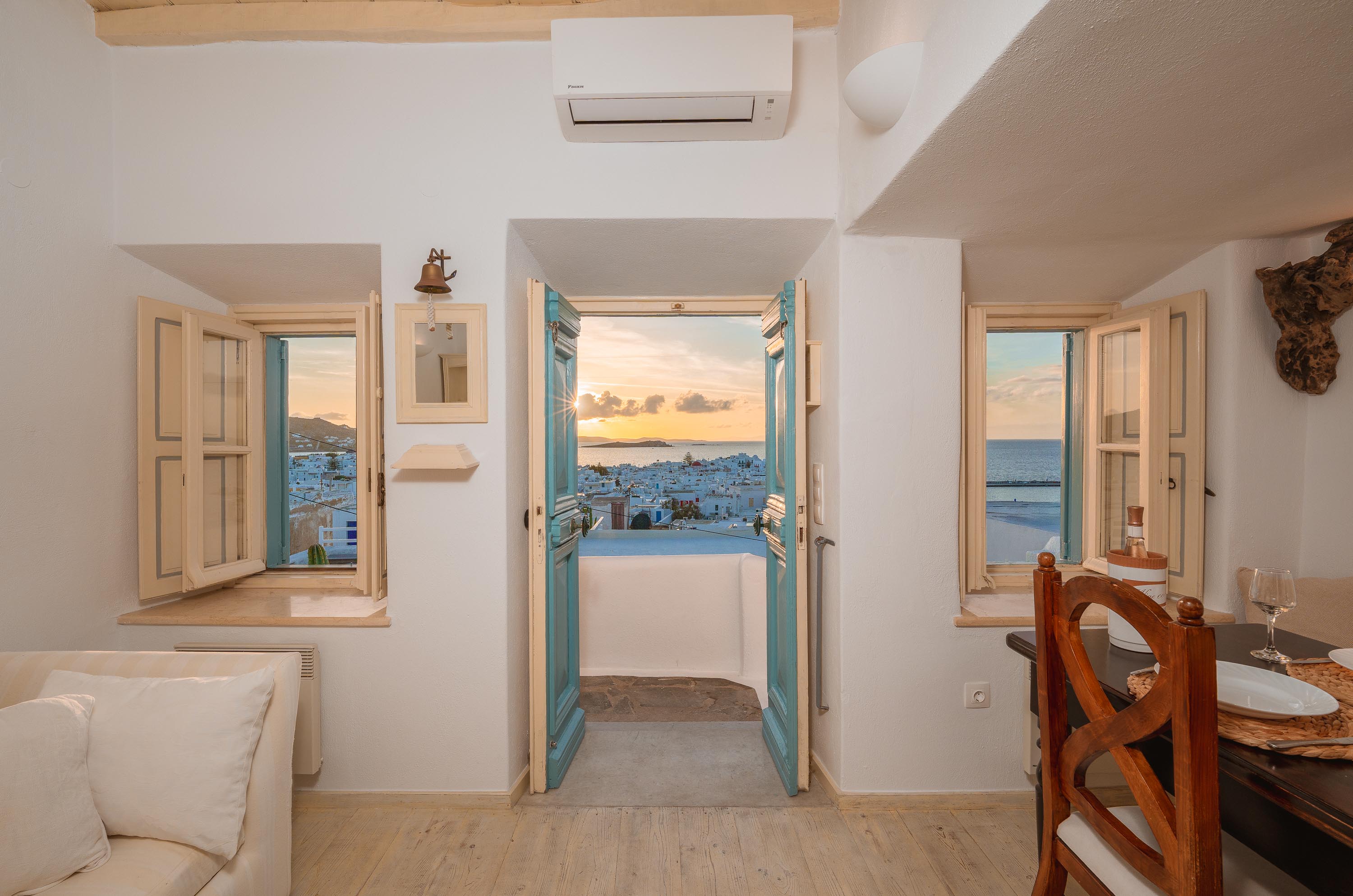Teal doors open to Mykonos sunset